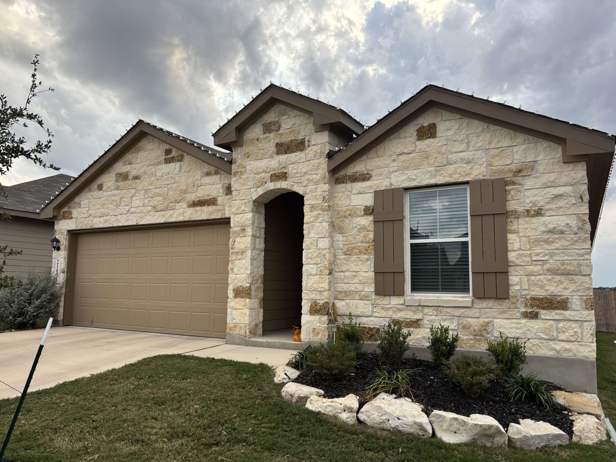 Single story stone home in San Antonio during daytime before holiday light installation by Urban Landscaping